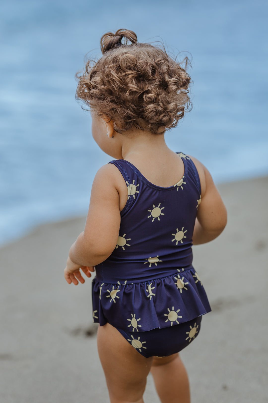 Traje de baño azul marino con soles amarillos