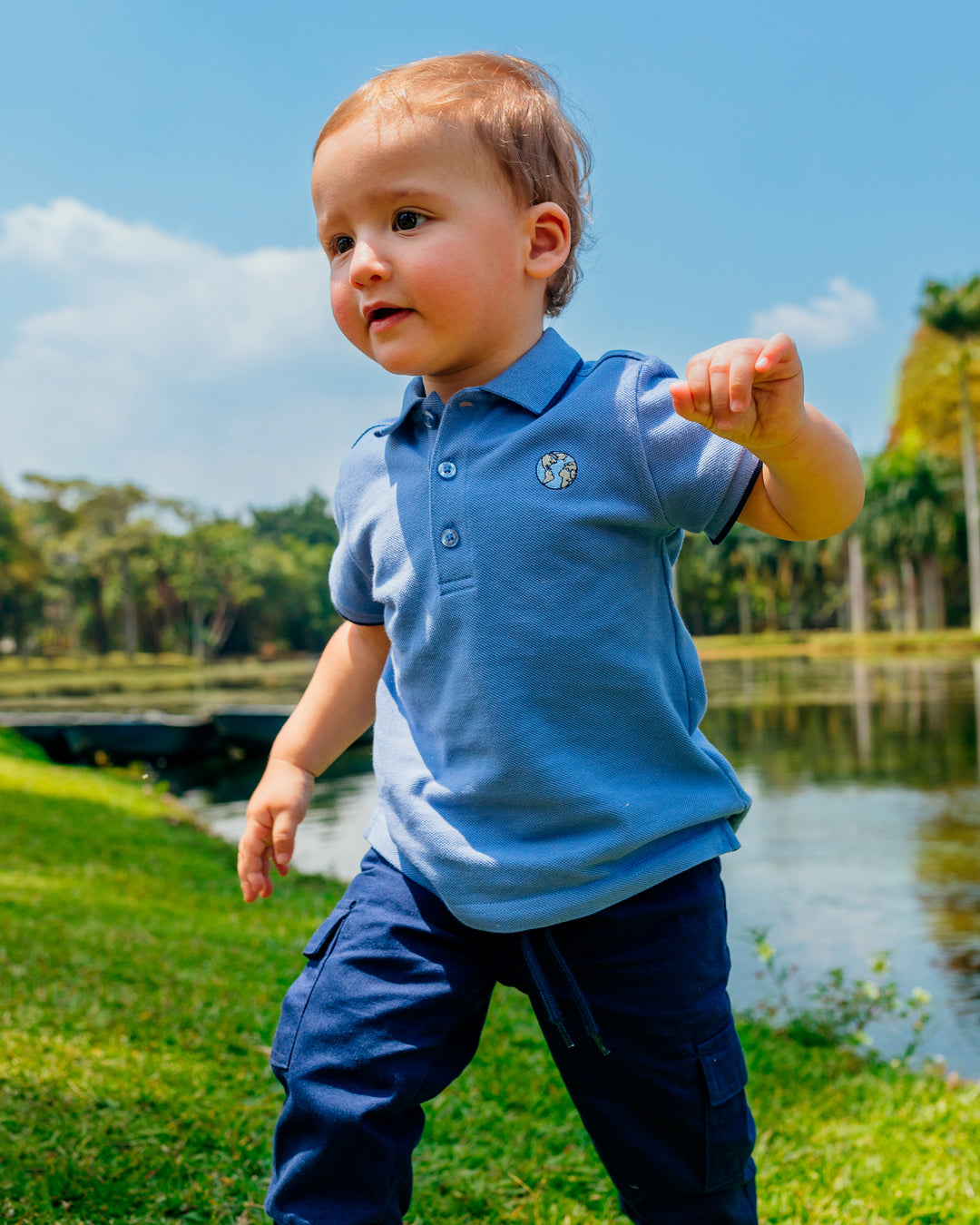 Chemise azul manga corta con rayas azul marino en mangas y cuello, con un planeta bordado