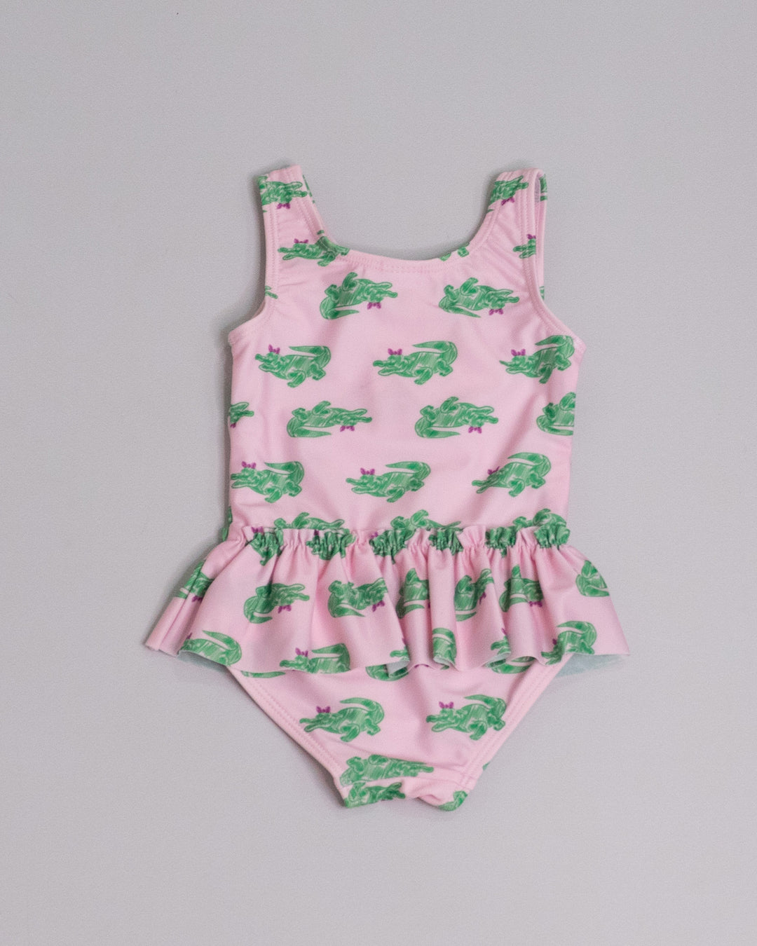 Traje de baño rosado con estampado de cocodrilos verdes